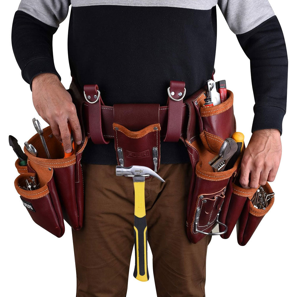 A close view of man's waist wearing Fueri 19 pockets maroon leather tool pouch with Fueri maroon leather foam padded soft mesh tool belt. Tools in all pockets. Hammer hanging in hammer holder